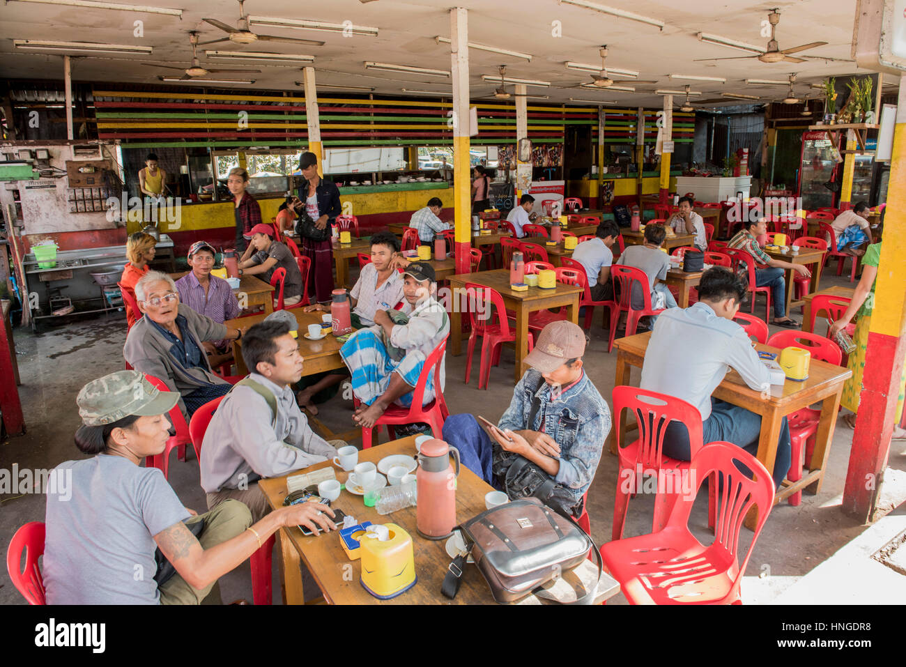 Typical scene in a tea shop in Yangon with men relaxing during the daytime Stock Photo