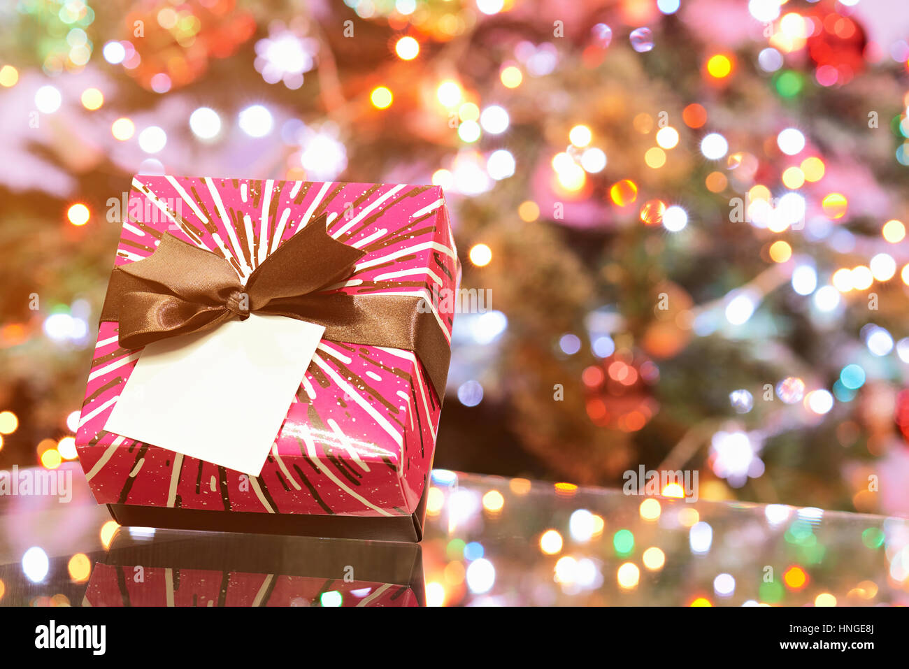 pink colorful gift box for christmas evening on blurred light background Stock Photo