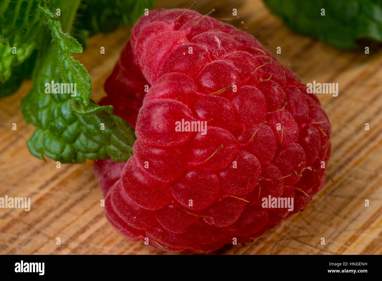 Woodcut Raspberry raspberry on wood with mint close up Stock Photo - Alamy