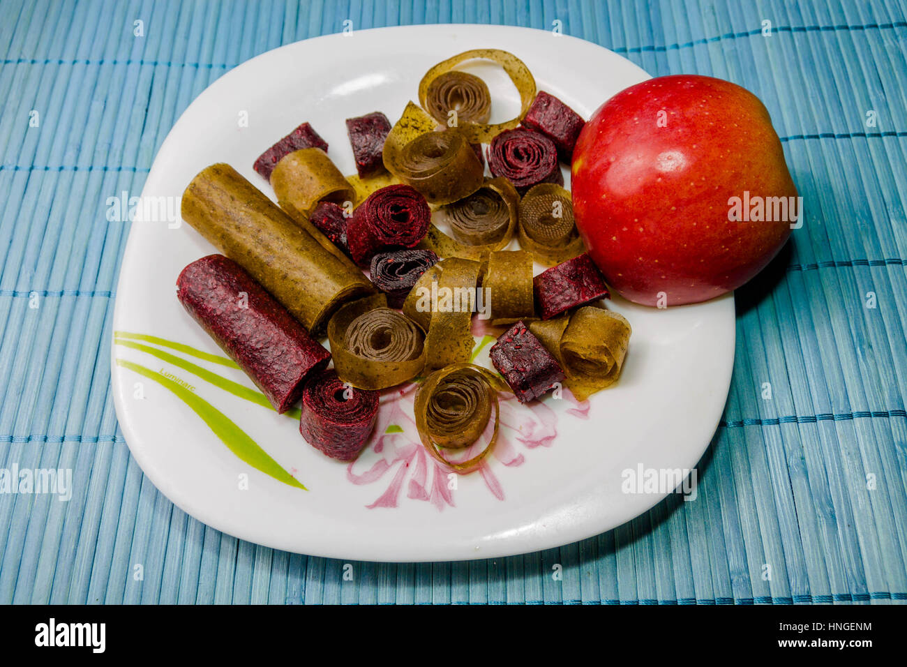 Variety of sweets on the plate. Color sweets and an apple. Sweets from fruits and berries. Stock Photo
