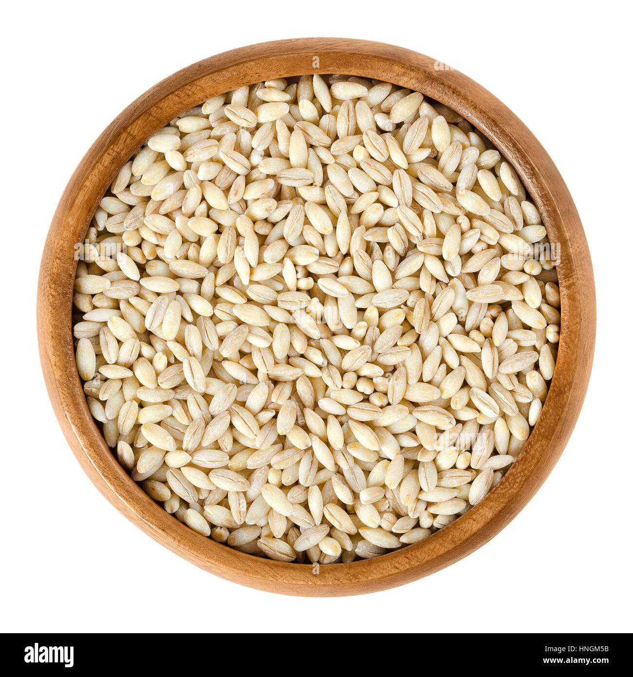 Processed pearl barley in wooden bowl. Uncooked pearled barley without hull and bran. Hordeum vulgare, a major cereal grain. Stock Photo