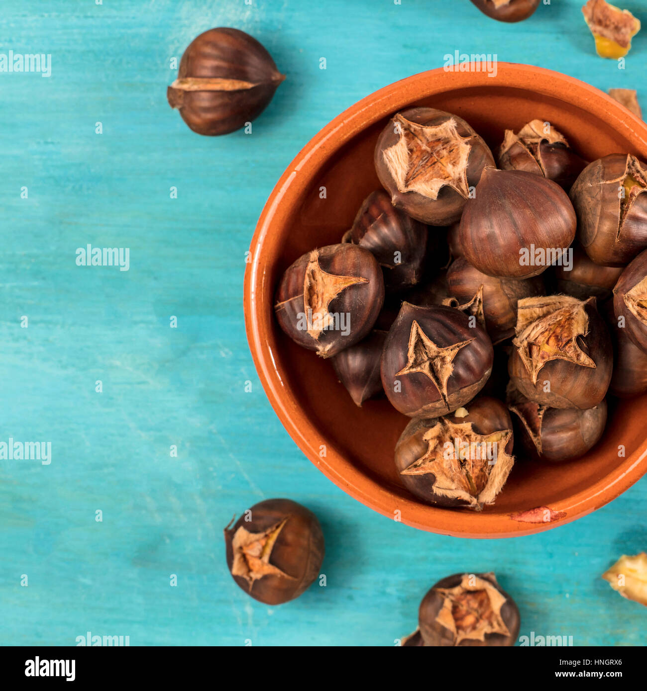 A square photo of peeled and unpeeled roasted chestnuts in an ...