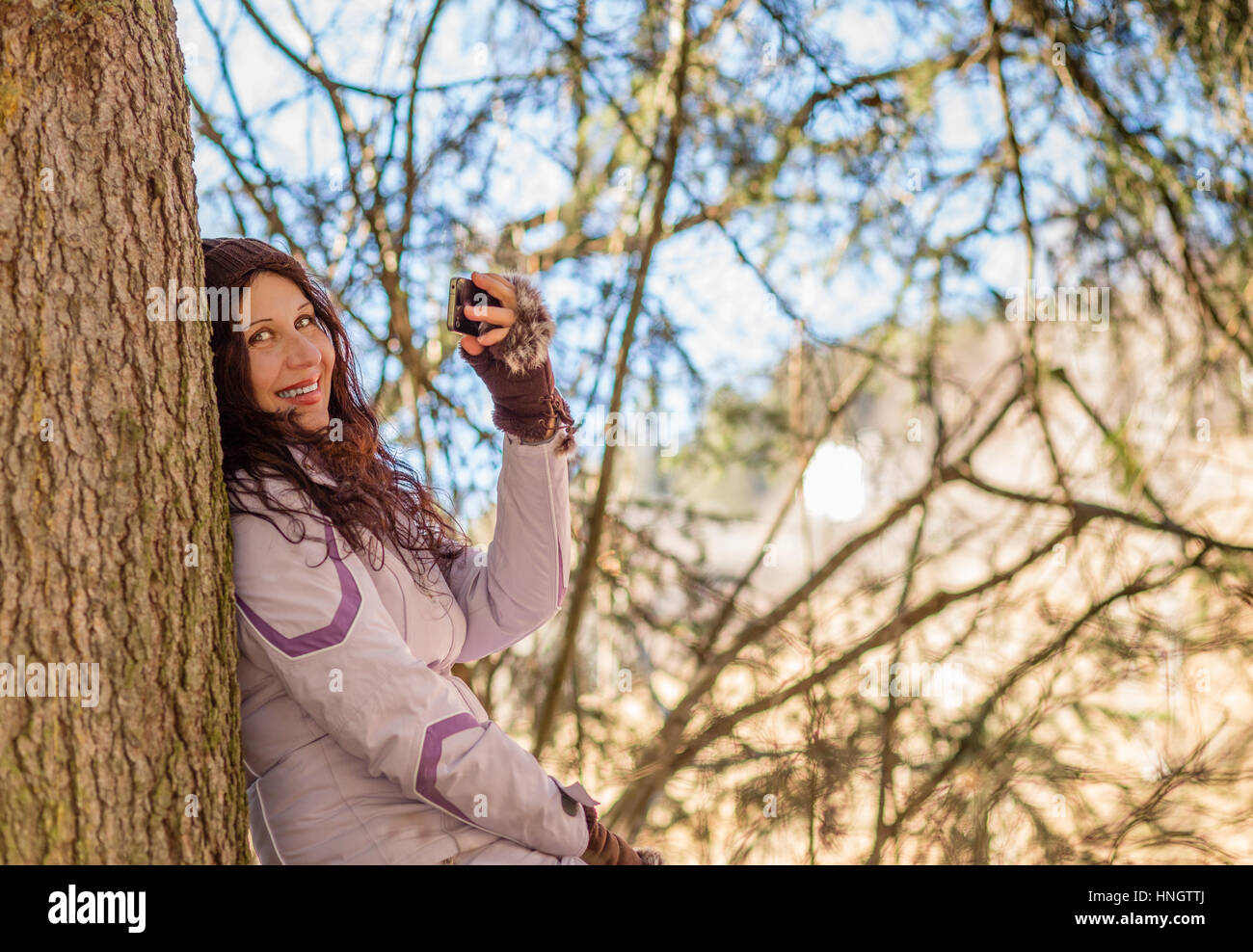 in the mountains a young retired woman is taking selfie and happy while ...