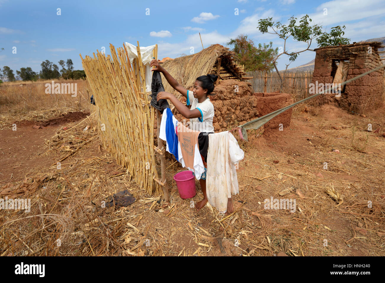 Woman hangs wet clothes on a clothes line, Analakely village, Tanambao commune, Tsiroanomandidy district, Bongolava region Stock Photo