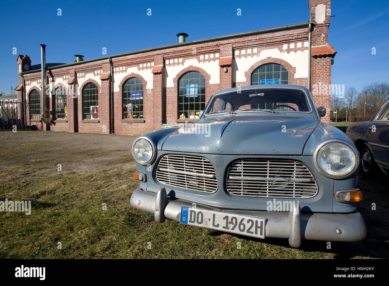 Germany, Waltrop, old Volvo Amazon car in front of a building of the former coal-mine Waltrop Stock Photo