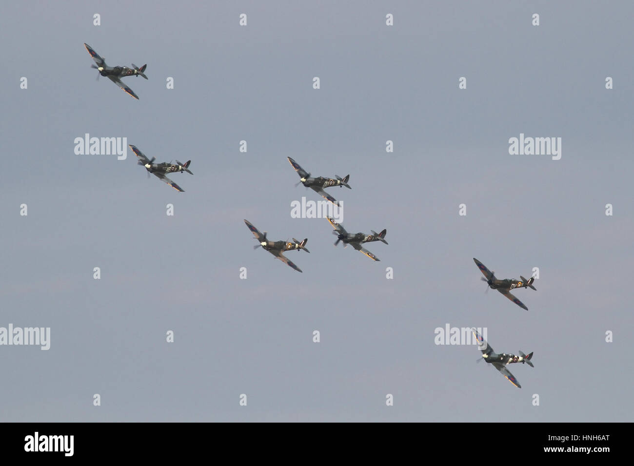 Seven Spitfires of various marks and including several two-seat conversions with a formation flypast at a Duxford airshow. Stock Photo