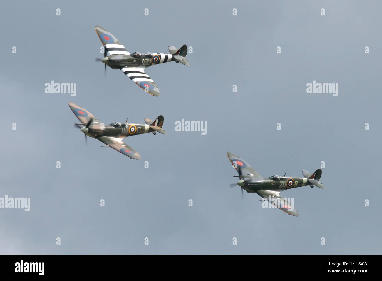 Three Supermarine Spitfires, a MkV, MkIX and a T9 in a vic of three with a flypast at a Duxford airshow. Stock Photo