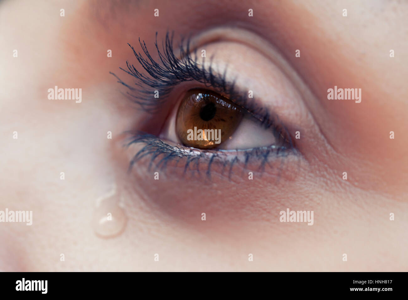 Horizontal closeup shot of female with a tear bleeding out of her eye