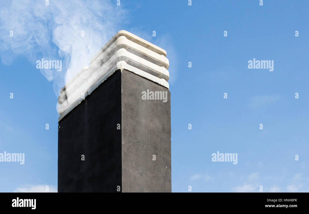 Smoke raising from a chimney in winter day against blue sky Stock Photo ...