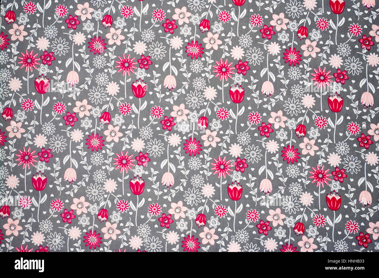 Red Pink and White Repetative Printed Flowers Floral Pattern On Grey Cloth Background Stock Photo