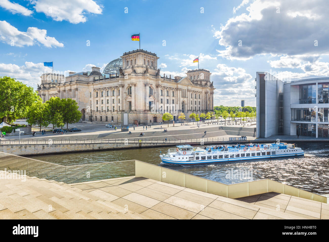 Berlin government district with excursion boat on Spree river passing famous Reichstag building and Paul Lobe Haus on a sunny day, central Berlin Stock Photo