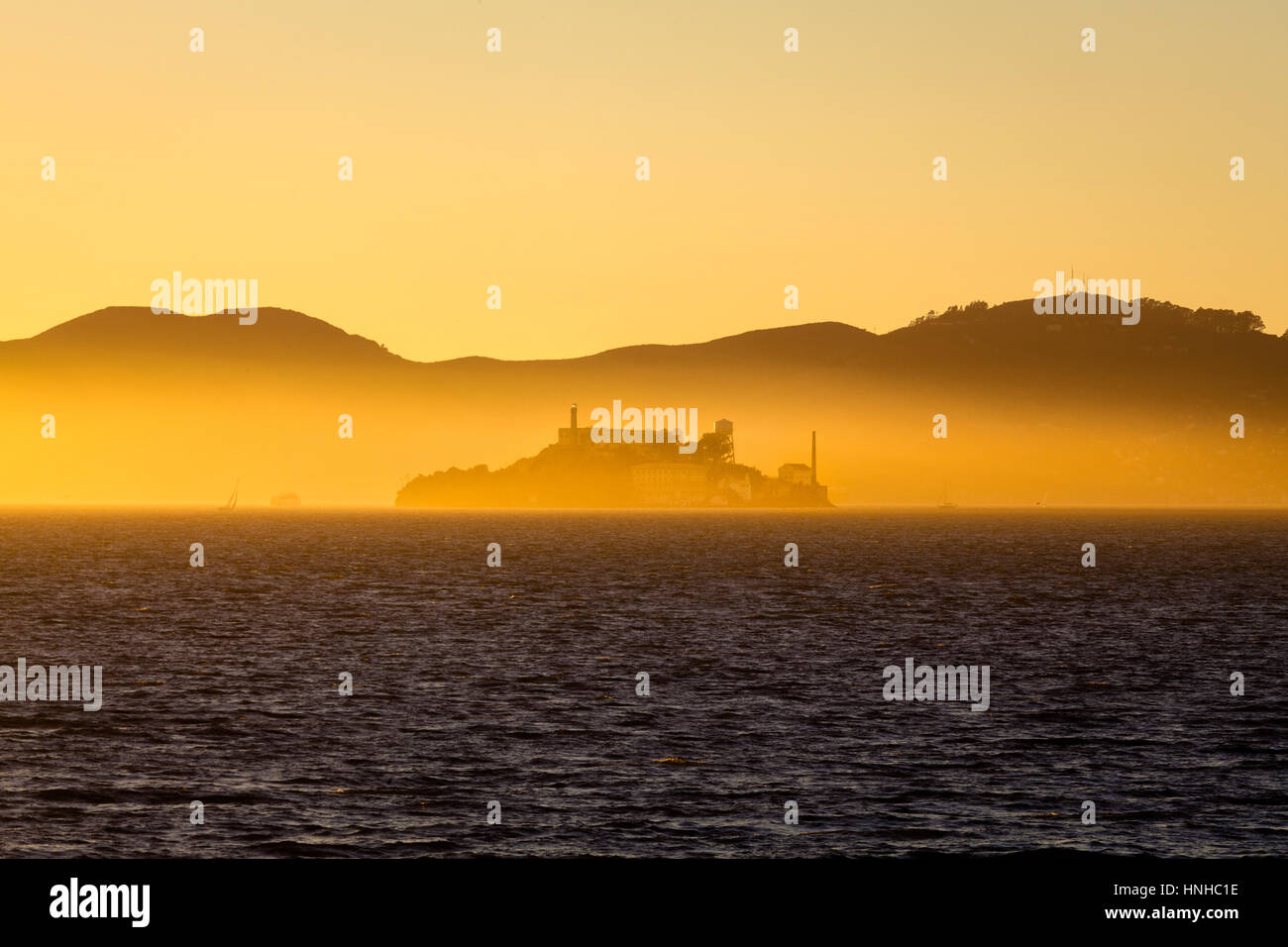 Beautiful view of famous Alcatraz Island illuminated in majestic golden evening light at sunset in summer, San Francisco Bay, California, USA Stock Photo