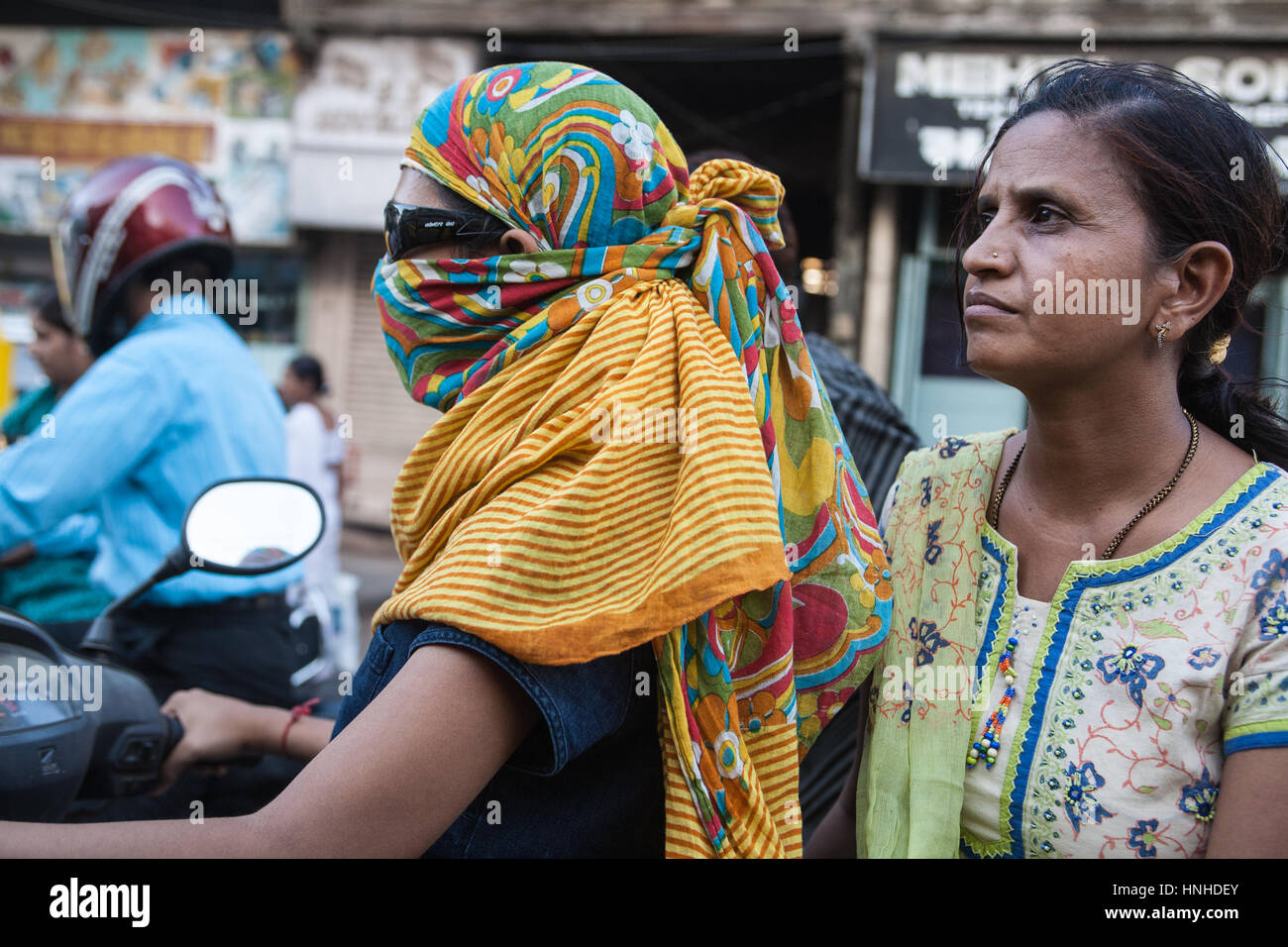 Traffic,motorbikes,scooters,pollution,pillion,passengers,wearing,face,masks,covered,fumes,pollution,Ahmedabad,Gujurat,India,Asia,Asian, Stock Photo