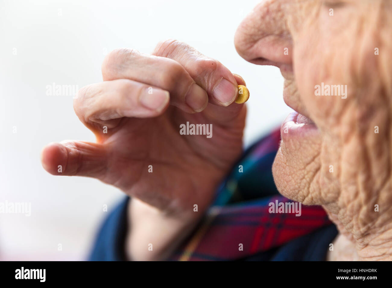 Elderly Turkish woman holding a single pill in her palm Stock Photo