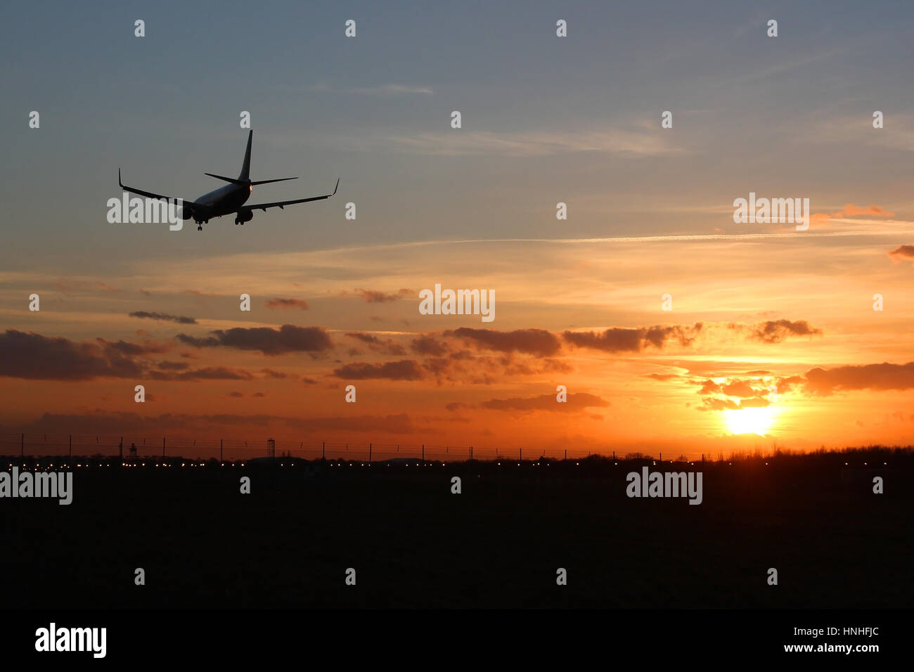 Boeing 737 airliner landing at Stansted Airport on runway 22 as the sun sets. Stock Photo