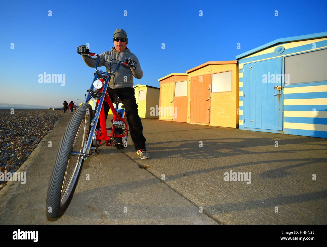 Seaford, East Sussex, UK. 13th Feb, 2017. UK Weather. Charlie enjoying in the evening sun after a beautifully sunny day in Sussex, riding an American Schwinn custom cruiser bike. Credit: Peter Cripps/Alamy Live News Stock Photo