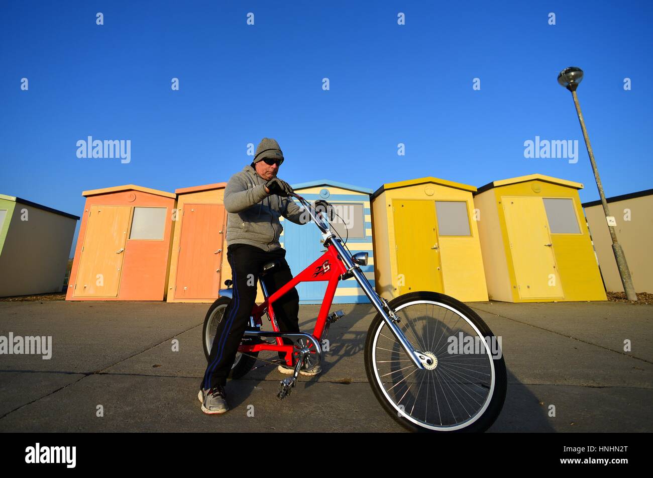 Seaford, East Sussex, UK. 13th Feb, 2017. UK Weather. Charlie enjoying in the evening sun after a beautifully sunny day in Sussex, riding an American Schwinn custom cruiser bike. Credit: Peter Cripps/Alamy Live News Stock Photo