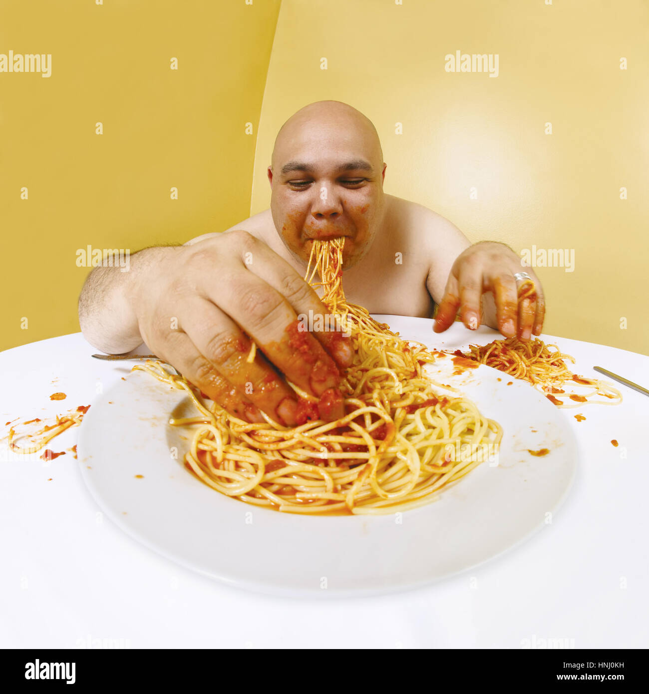 Photo of an overweight man enjoying a plate of spaghetti. Shot with fisheye lens. Focus is on the face Stock Photo - Alamy