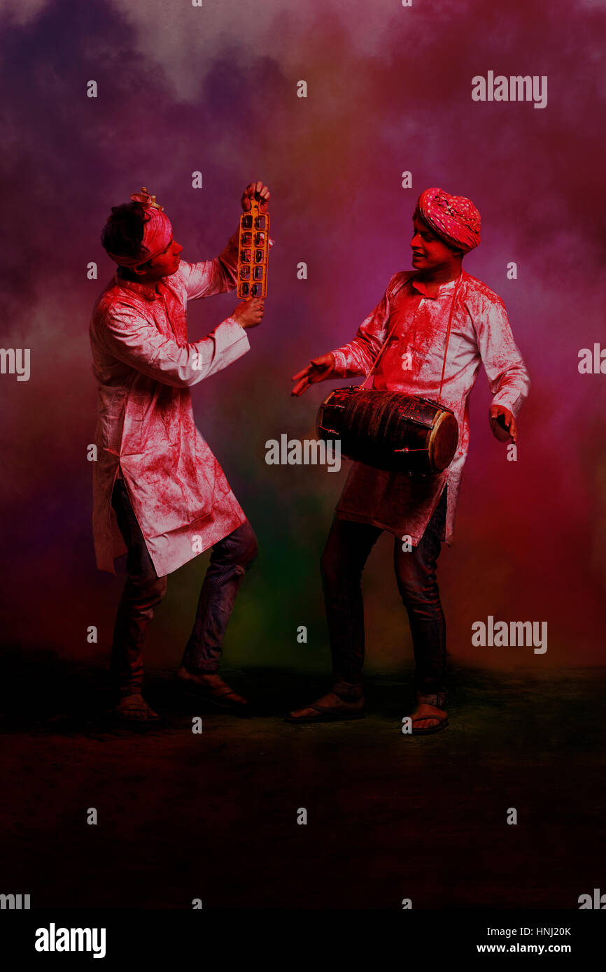 Two Young Indian men With Colored Face Dancing During Holi Color festival Stock Photo