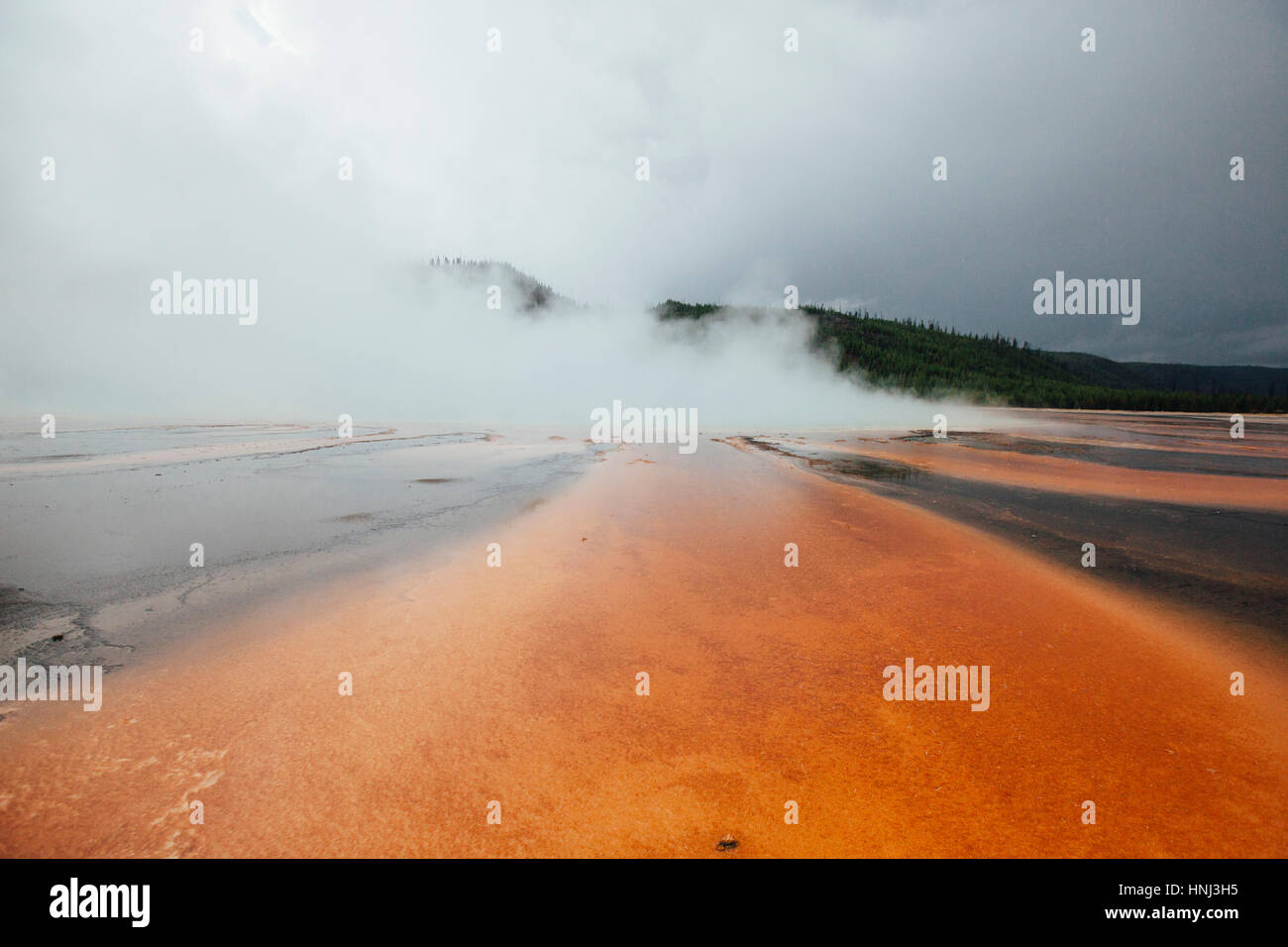 Grand prismatic spring against cloudy sky Stock Photo