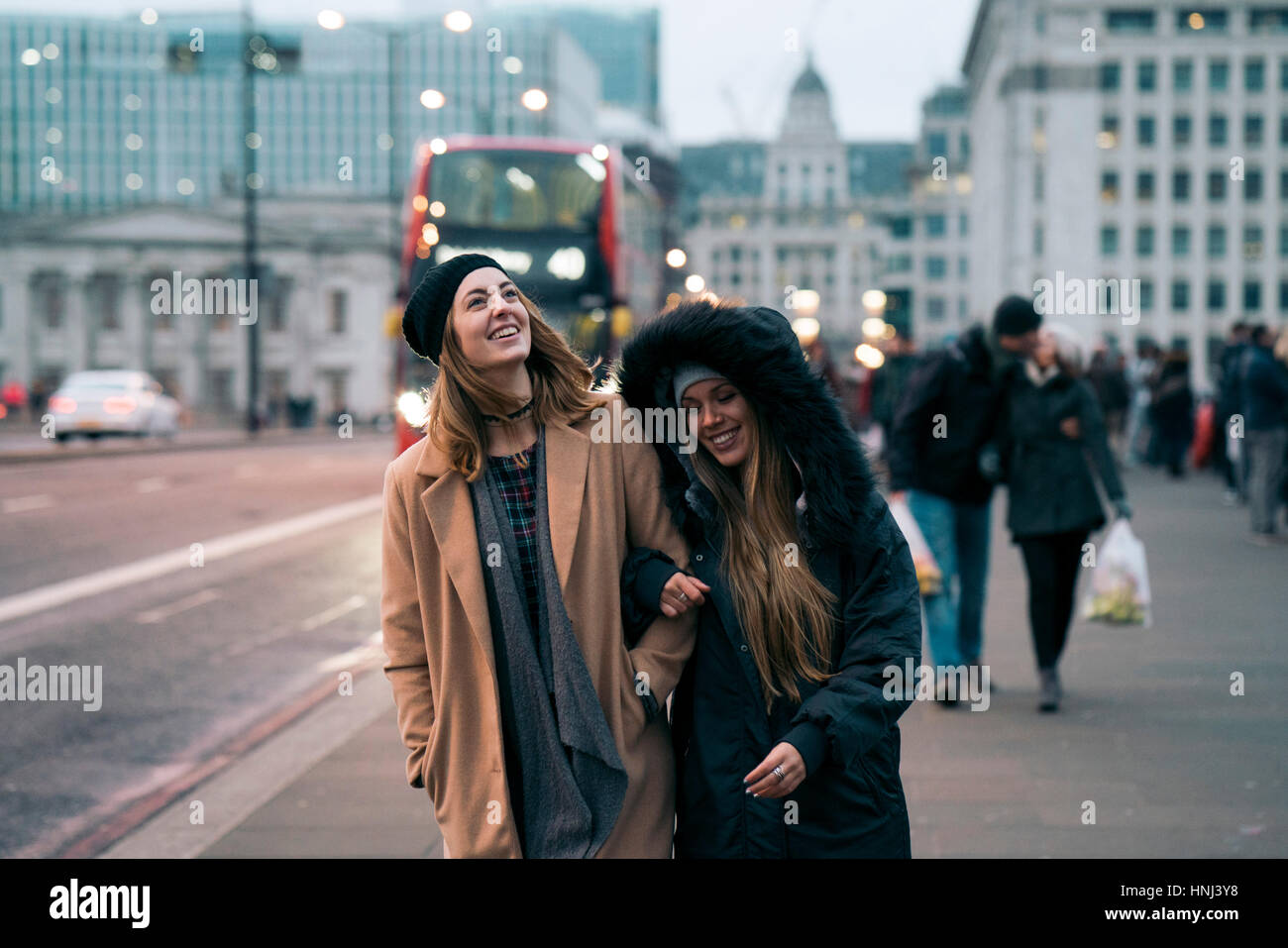 Smiling friends walking on road in city Stock Photo