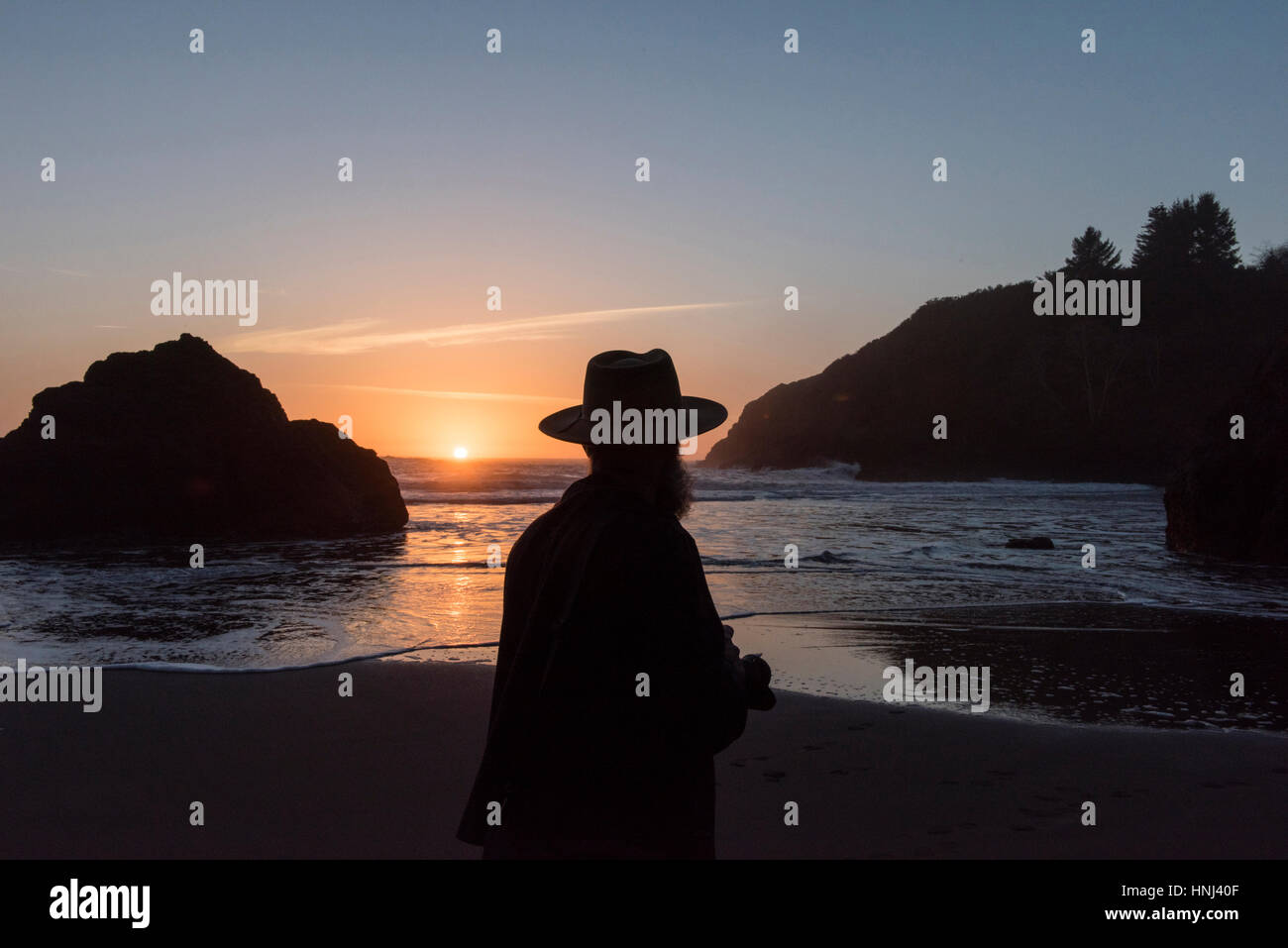 Silhouette man standing at beach during sunset Stock Photo - Alamy