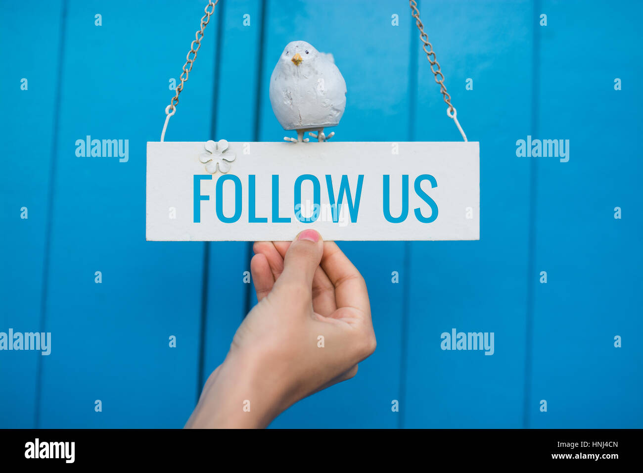 Follow Us signboard on a blue wooden background Stock Photo