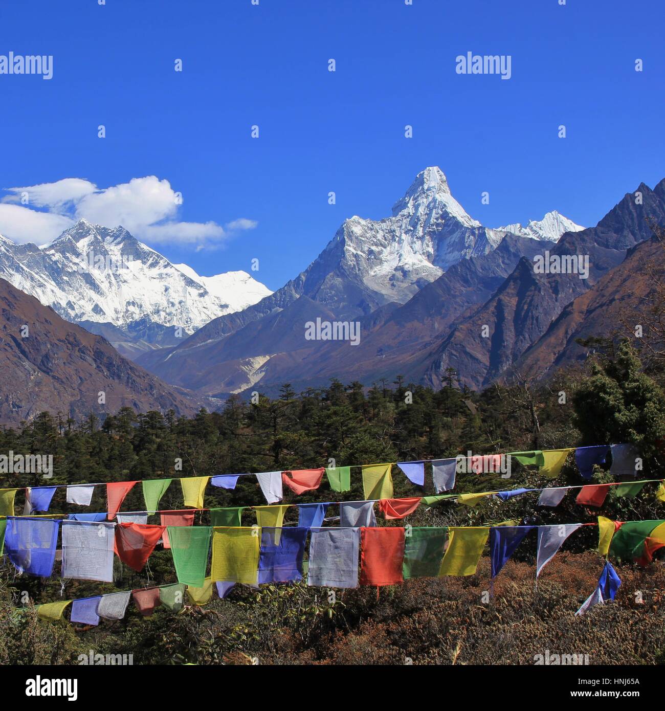 Autumn day in the Everest National Park. Snow capped mountains Lhotse and Ama Dablam. Prayer flags. Stock Photo