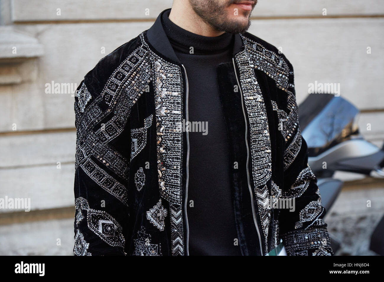 MILAN - JANUARY 16: Man with black velvet jacket with gems and sequins decorations before Cedric Charlier fashion show, Milan Fashion Week street styl Stock Photo