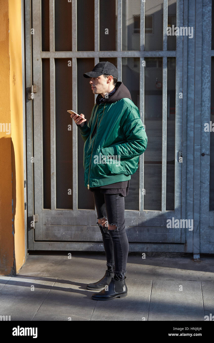 MILAN - JANUARY 17: Man with green bomber jacket before Giorgio Armani fashion show, Milan Fashion Week street style on January 17, 2017 in Milan. Stock Photo