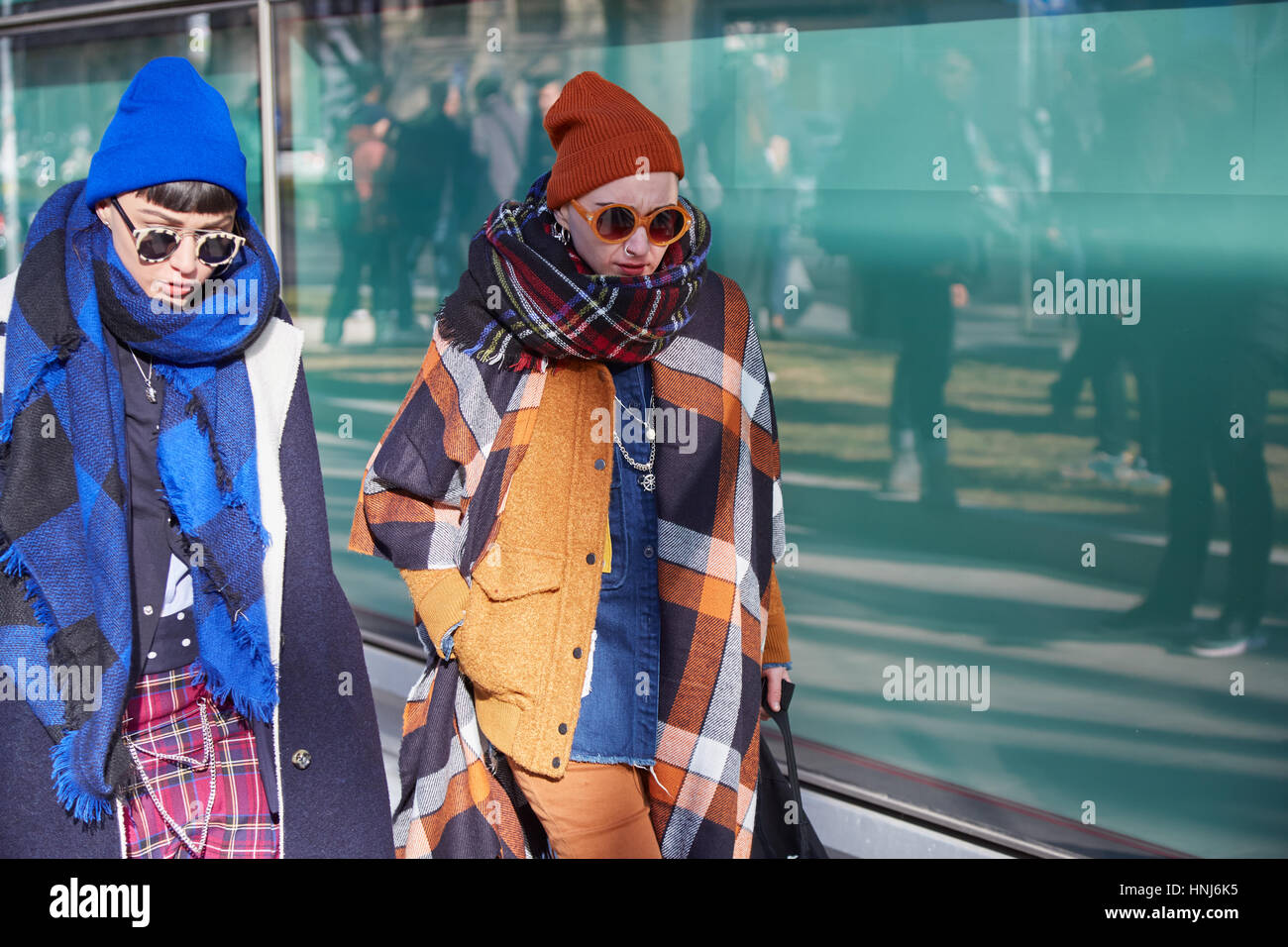 Women in blue and orange before Giorgio Armani fashion show, Milan Fashion Week street style on January 17, 2017 in Milan Stock Photo