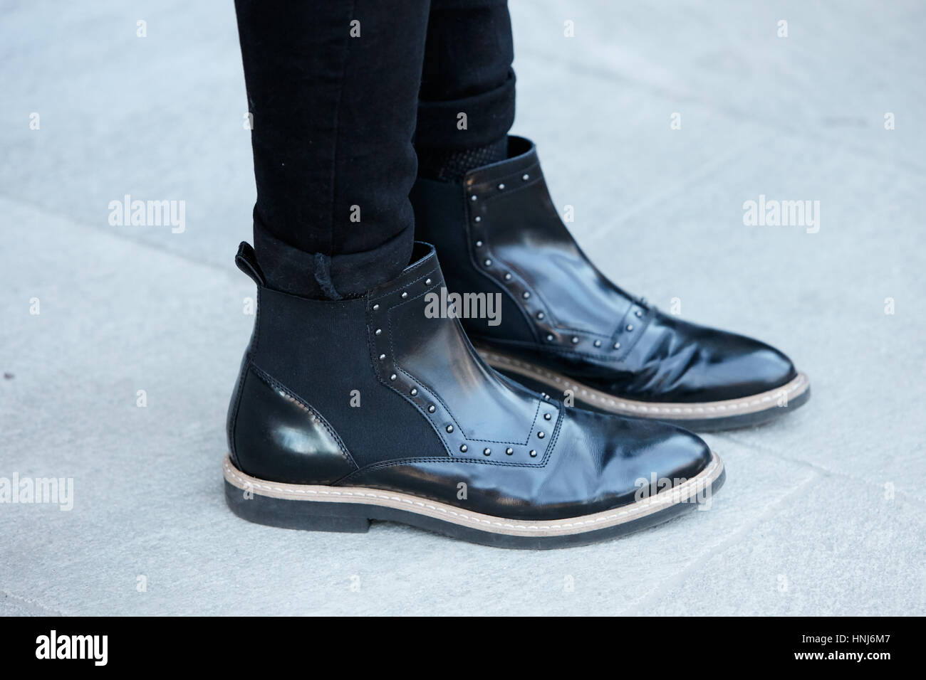 Man with black leather boots with studs before Emporio Armani fashion show, Milan Fashion Week street style on January 14, 2017 Stock Photo