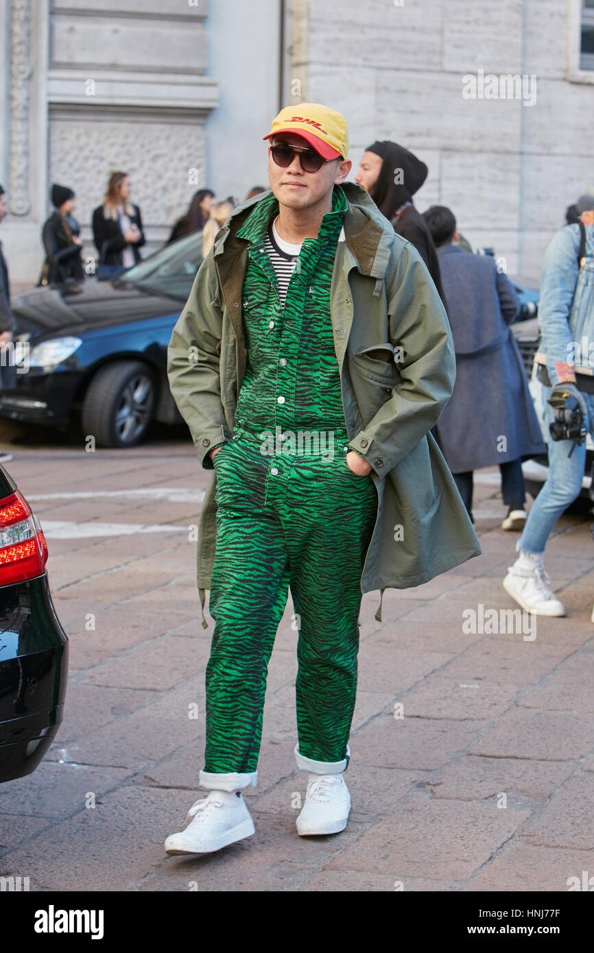 Man with green zebrine overalls and Dhl cap before Salvatore Ferragamo fashion show, Milan Fashion Week street style on January 2017. Stock Photo