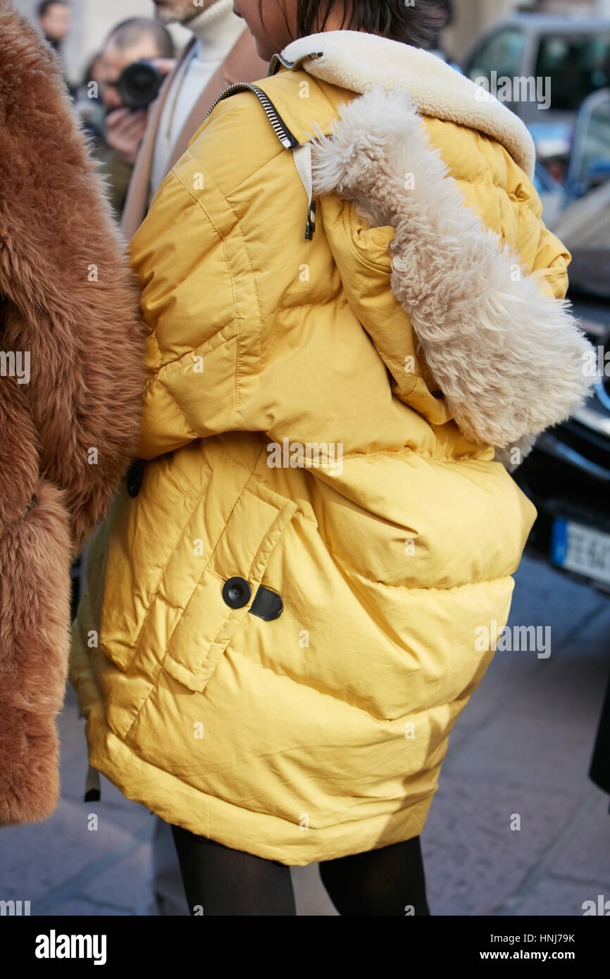Woman with yellow winter coat before Salvatore Ferragamo fashion show, Milan Fashion Week street style on January 15, 2017 in Milan. Stock Photo