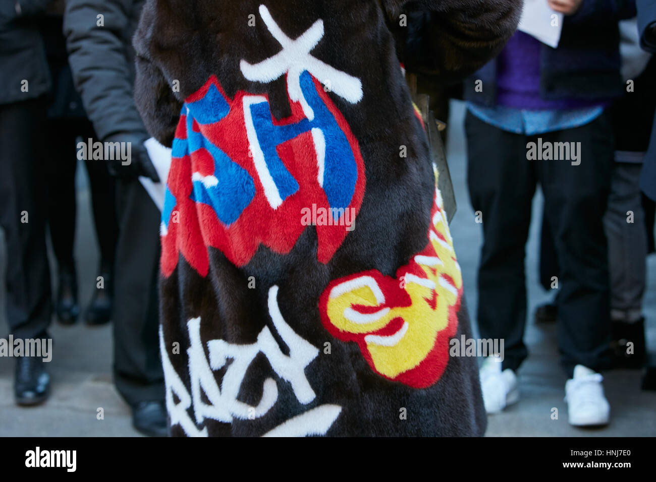 Woman with brown fur coat with writers colorful design before N 21 fashion show, Milan Fashion Week street style on January 16, 2017. Stock Photo