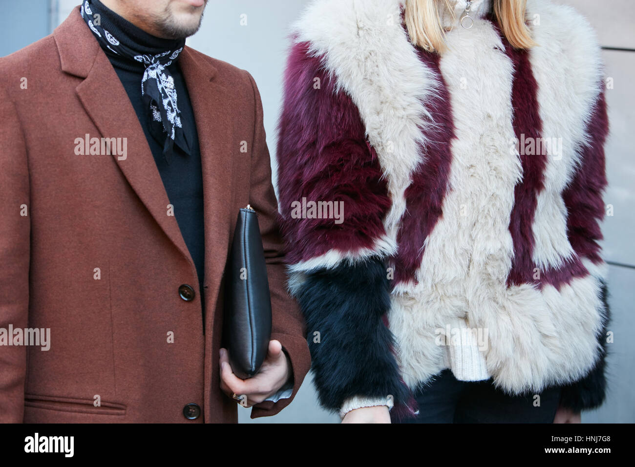Man and woman with brown jacket and dark red and white fur before N 21 fashion show, Milan Fashion Week street style on January 16, 2017. Stock Photo