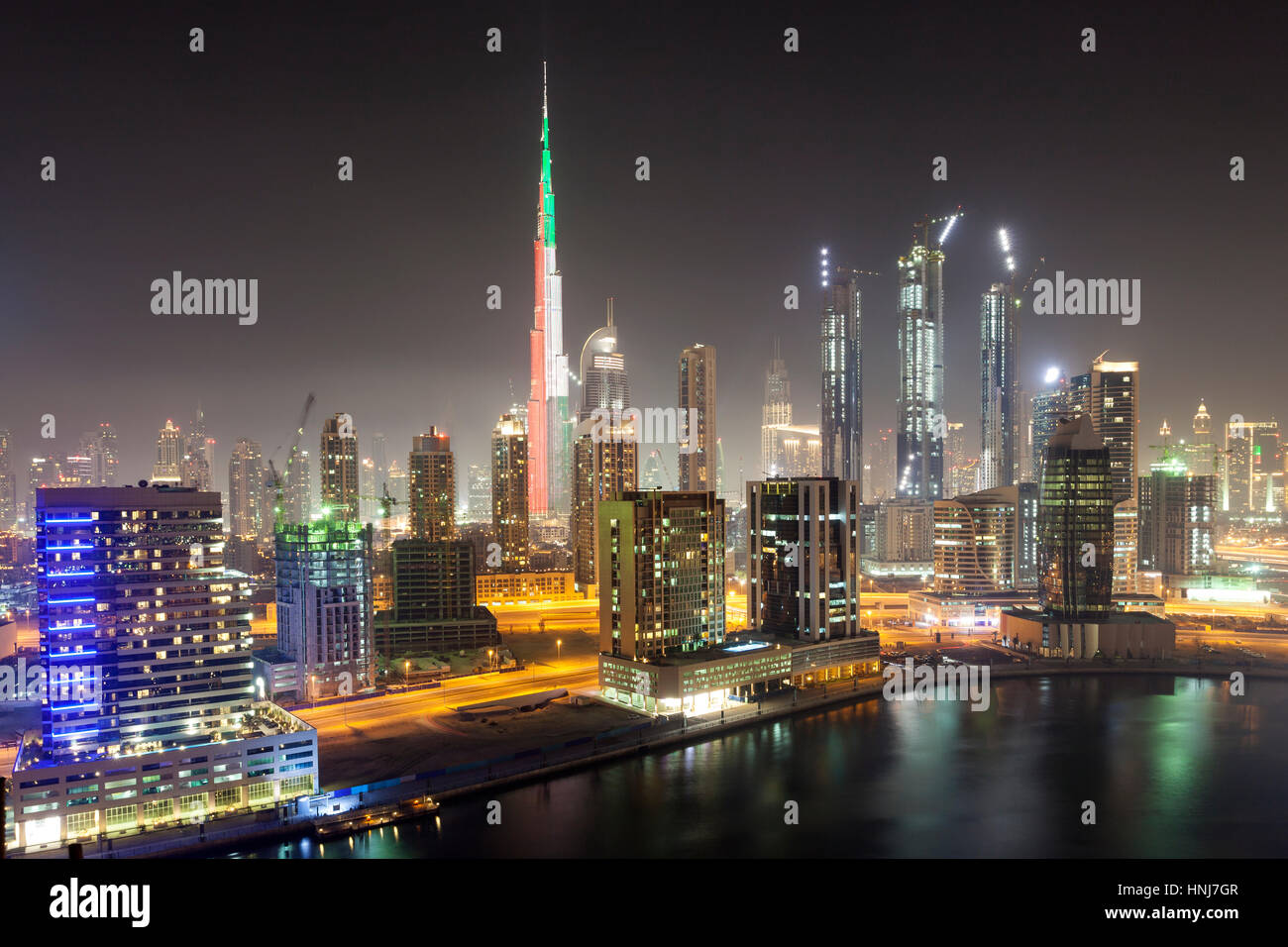 Skyline of Dubai downtown at night. Burj Khalifa illuminated in national colors of the UAE - green, red and white. United Arab Emirates, Middle East Stock Photo