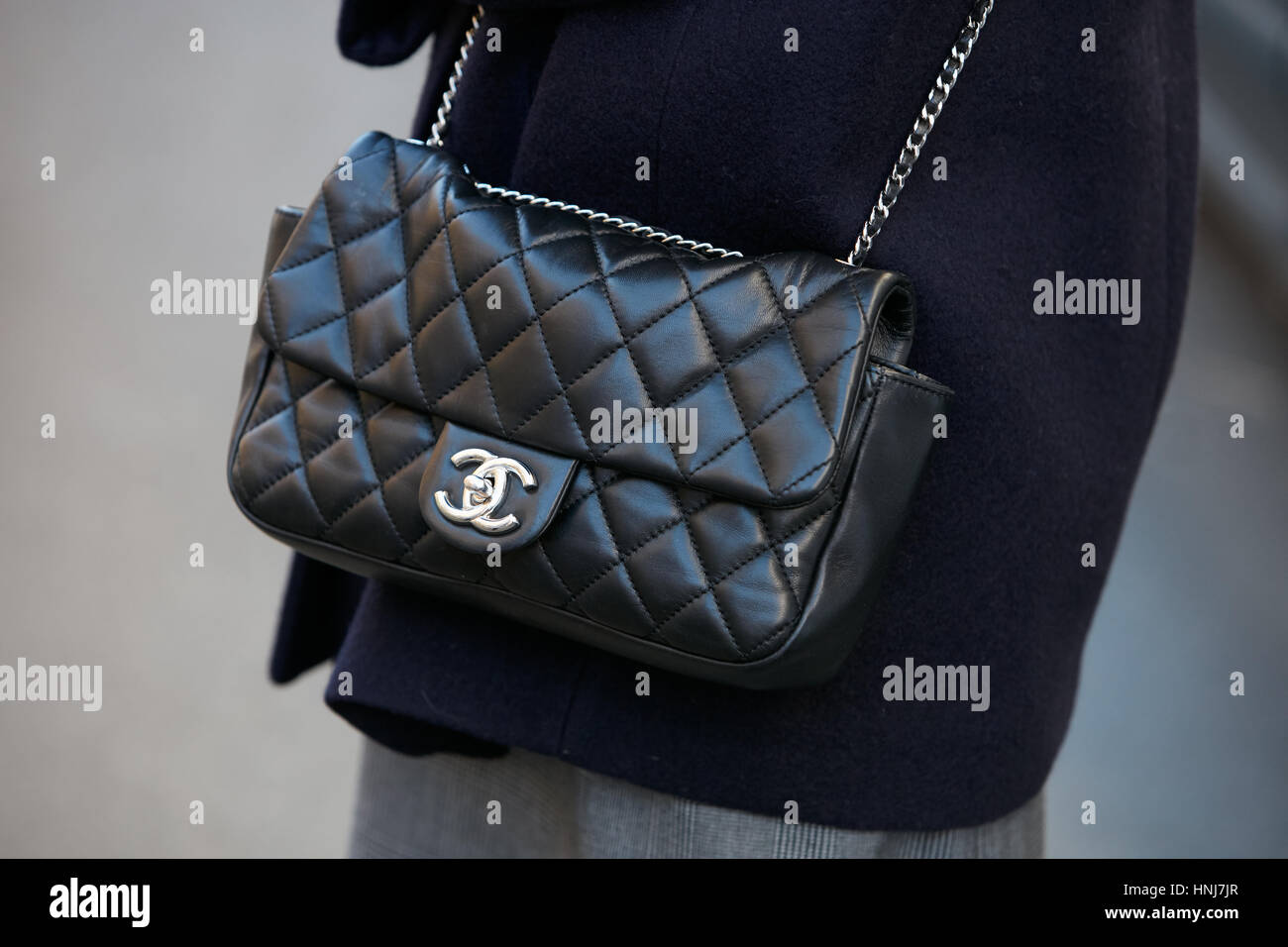 Woman with black leather Chanel bag with silver chain before N 21 fashion show, Milan Fashion Week street style on January 16, 2017. Stock Photo