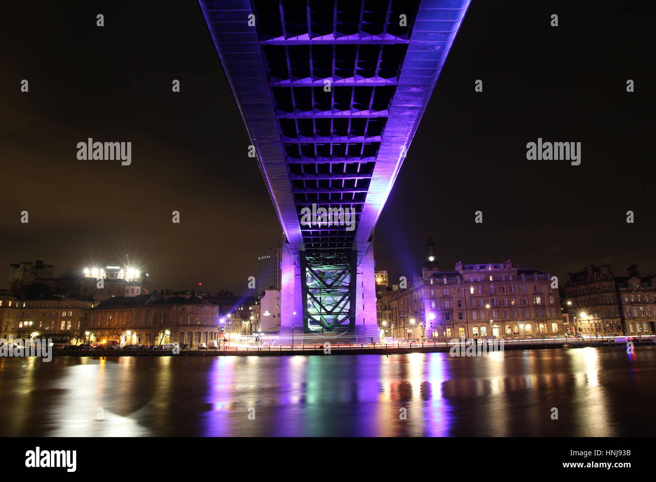 Striking view of the underside of the Tyne bridge in Newcastle-Upon-Tyne and the Quayside, both brightly lit Stock Photo