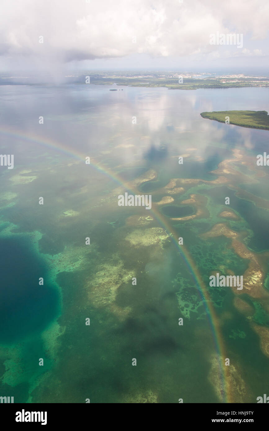 Aerial approach to Guadeloupe with mirrored rainbow and cloudscapes Stock Photo