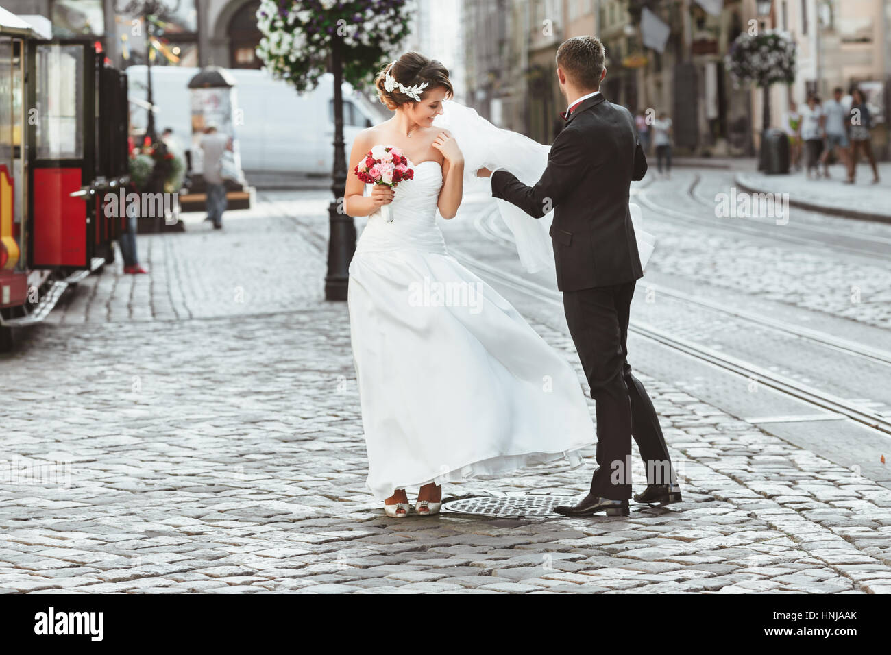 Bride and bridegroom walking in the city Stock Photo - Alamy
