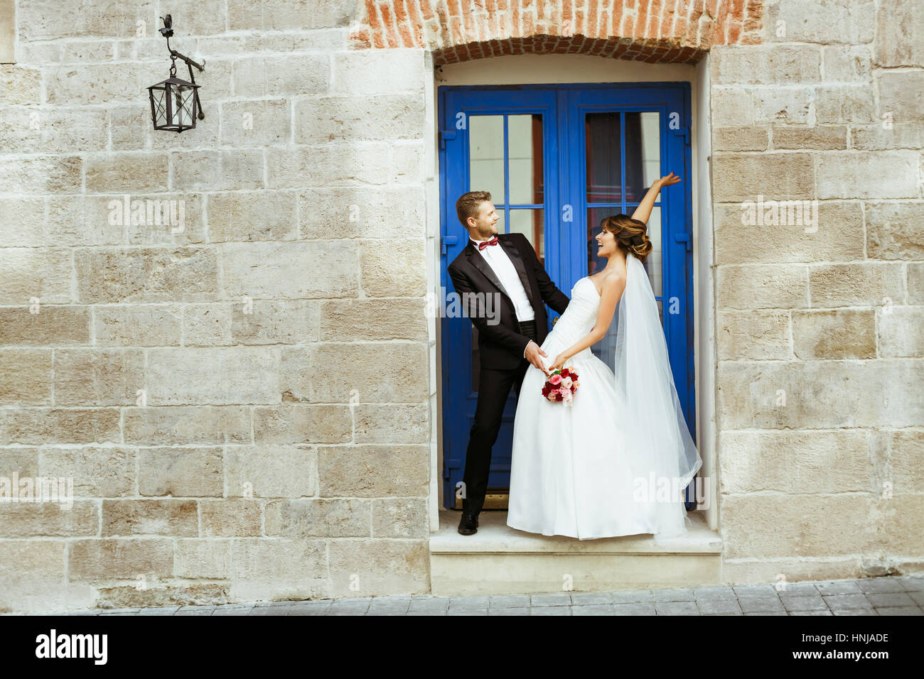 Bride and groom standing near blue door Stock Photo - Alamy