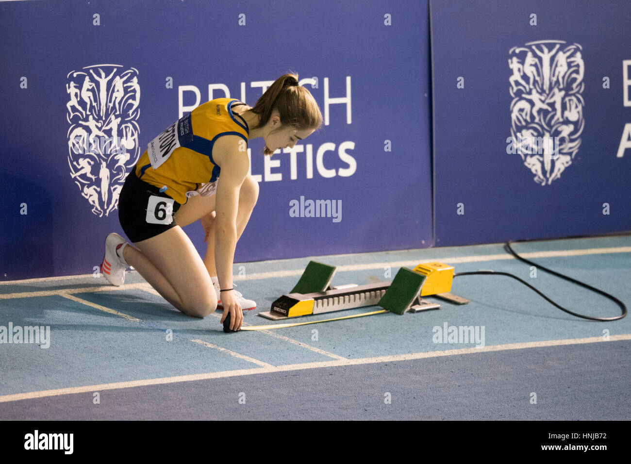 An athlete measure the position of her starting blocks at the British