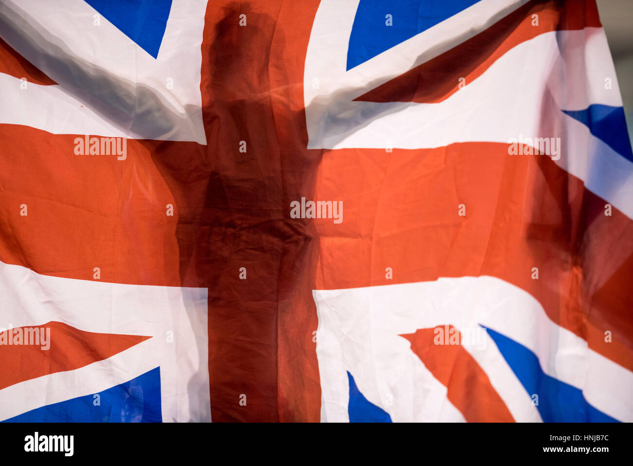 An athlete is silhouetted in a Union Flag at the British Athletics Indoor Team Trials at the English Institute of Sport, Sheffield, United Kingdom, on Stock Photo