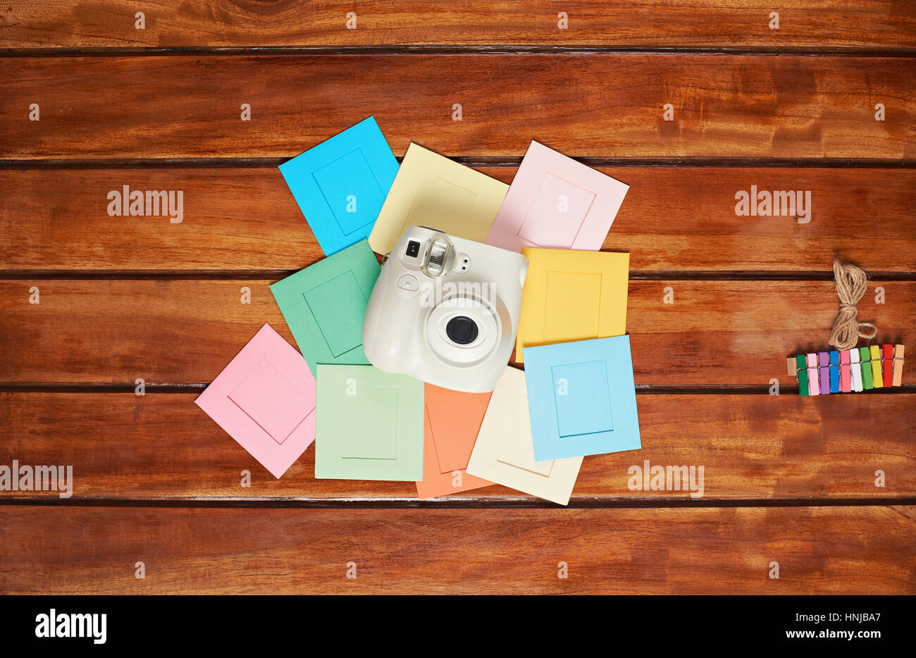 instant camera on top of colorful frames lay wooden table mockup Stock Photo