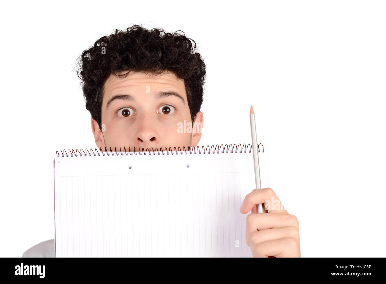Close up of a young student holding notebook and pencil. Isolated white background. Stock Photo