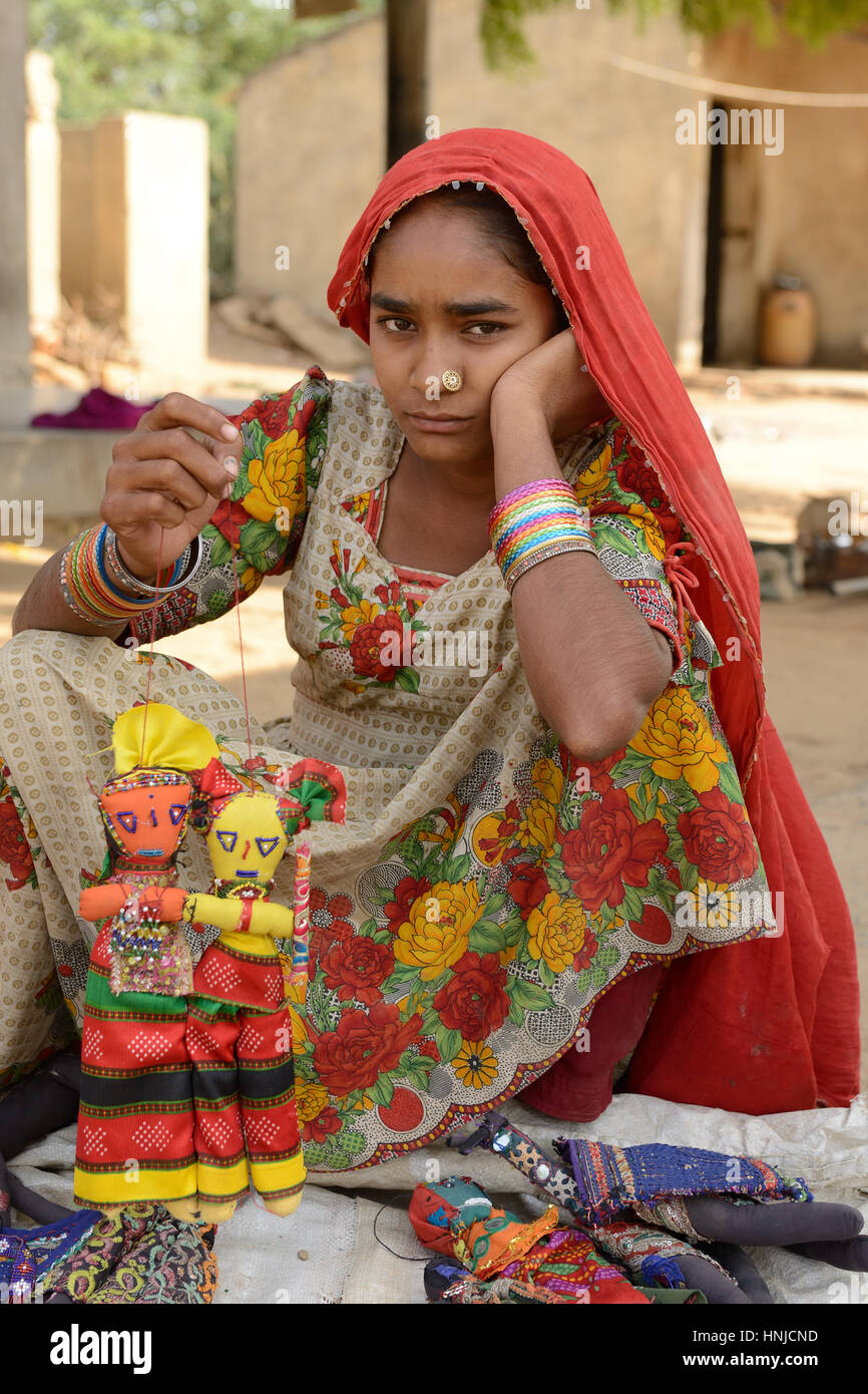 BHUJ, RAN OF KUCH, INDIA - JANUARY 14: The tribal woman in the traditional dress selling souvenirs for tourists in the ethnic village on the desert in Stock Photo