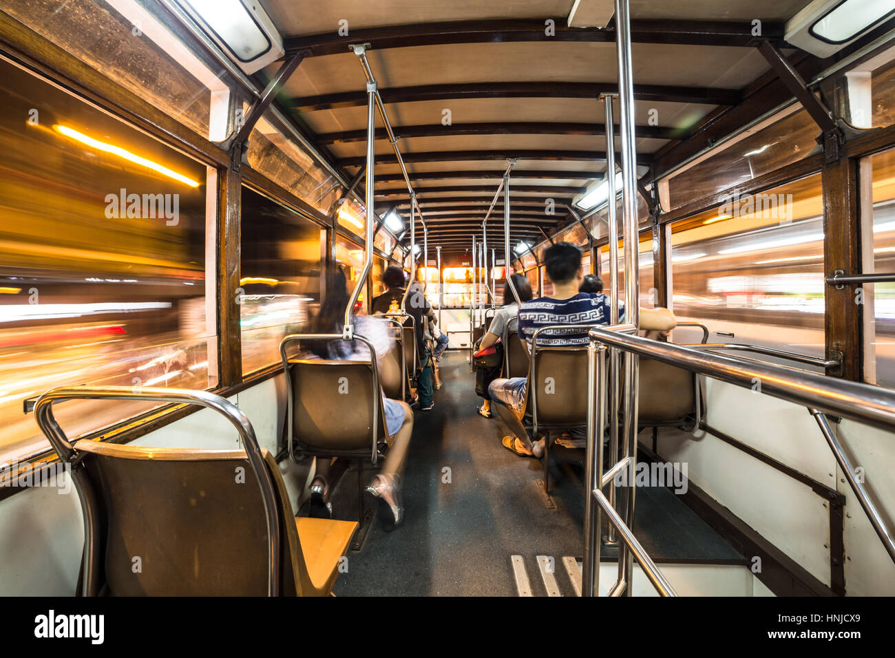 Interior of a Tram car rushing through Hong Kong island streets at night. Wide angle and long exposure are used. Stock Photo
