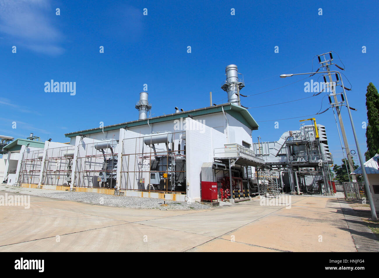 High-voltage power transformer in industrial power plant with blue sky Stock Photo