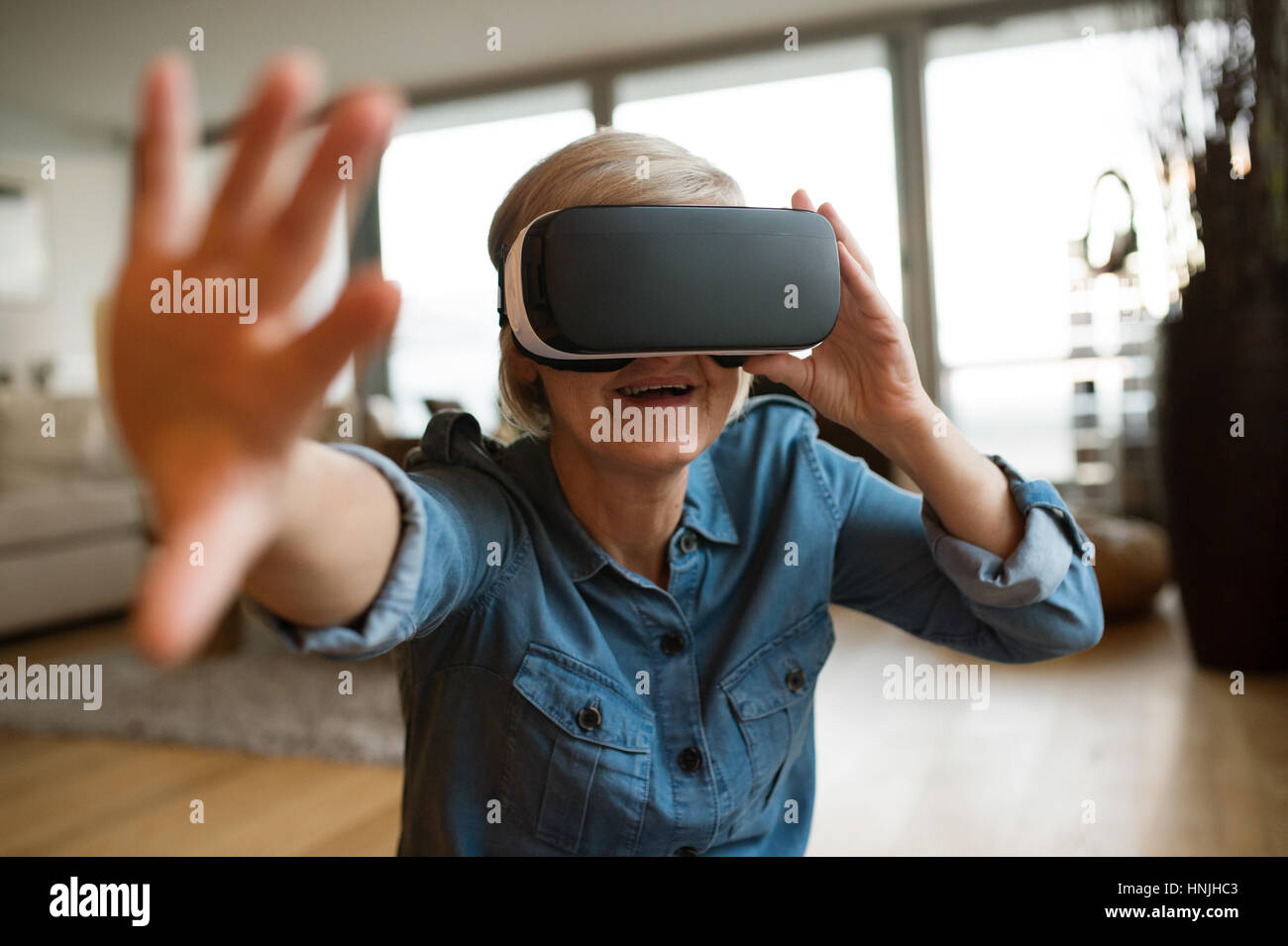 Senior woman wearing virtual reality goggles at home Stock Photo Alamy